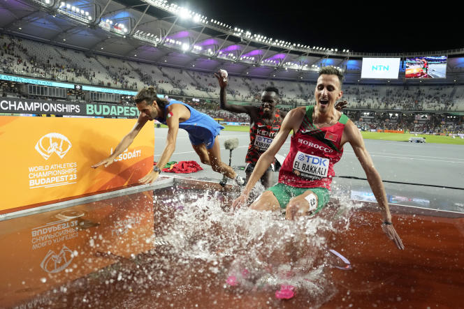 Gianmarco Tamberi, left, Soufiane El Bakkali, right, and Abraham Kibiwot, dive in the steeplechase river during the World Championships in Athletics in Budapest, Hungary, Tuesday August 22, 2023.