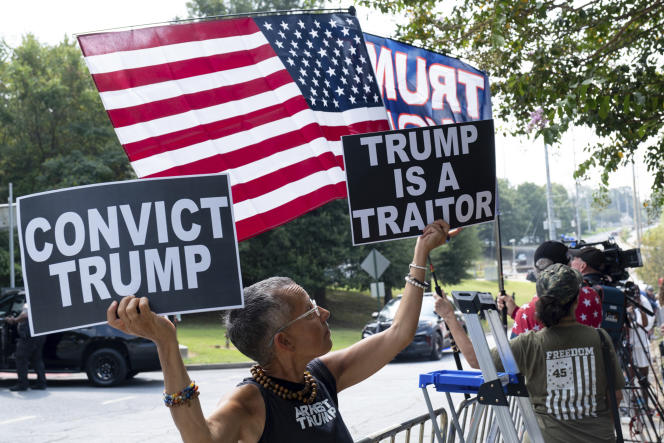 An opponent of Donald Trump demonstrates in front of the Atlanta prison, where the former president is expected Thursday, August 24. 