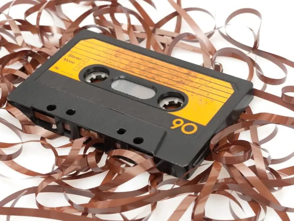 A cassette lies over a tangle of cables