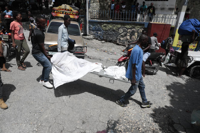 Mortuary workers carry a body in the Carrefour-Feuilles neighborhood of Port-au-Prince, Haiti.  August 15, 2023.