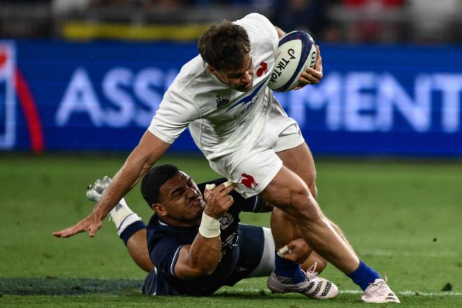 The winger of the XV of France, Damian Penaud, in the fight with the Scottish Sione Tuipulotu, on the lawn of the Geoffroy-Guichard stadium in Saint-Etienne, August 13, 2023.