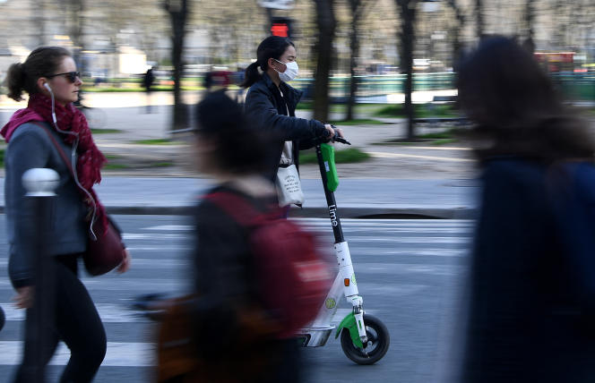 A woman rides a Lime scooter in Paris in March 2020.