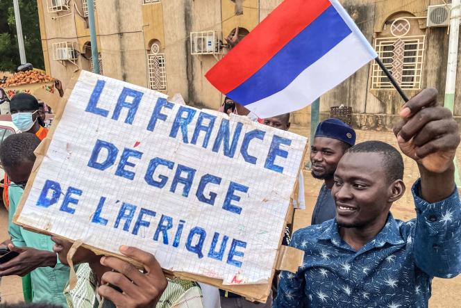 Demonstrators hold up a sign hostile to France, in Niamey, on August 3, 2023.