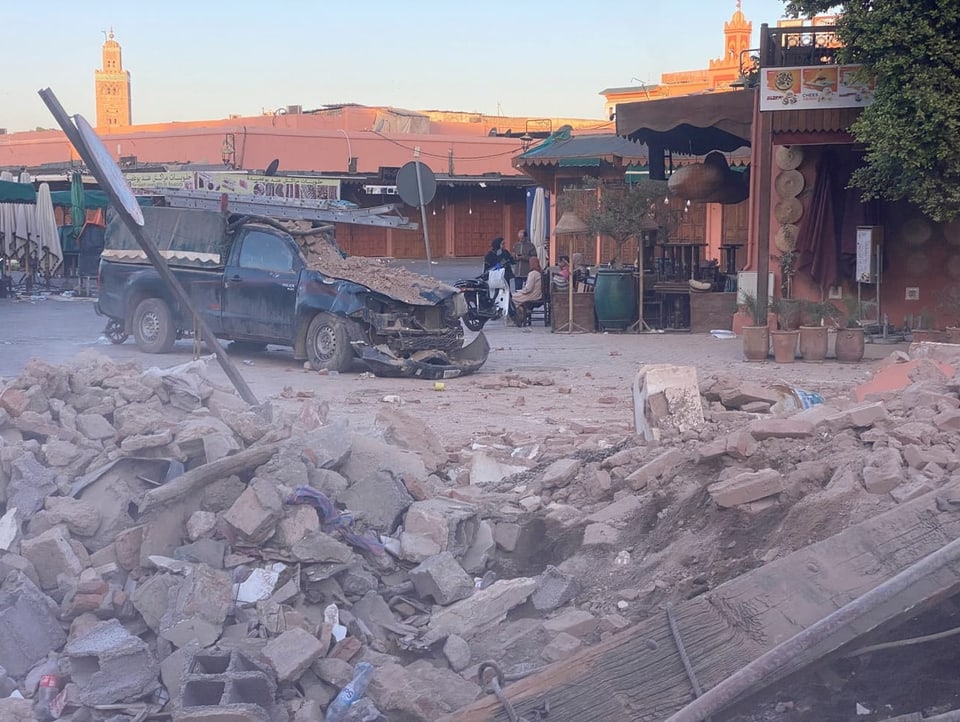 Debris and a destroyed car lie on a street in Marrakech.