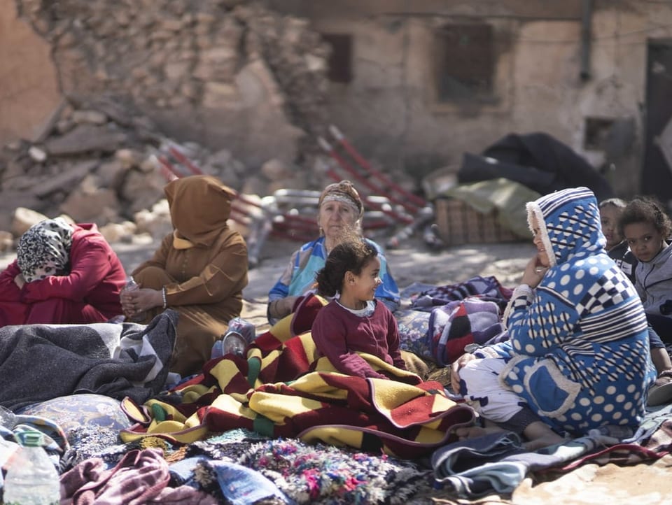 Families sit on blankets on the floor in Marrakesh.