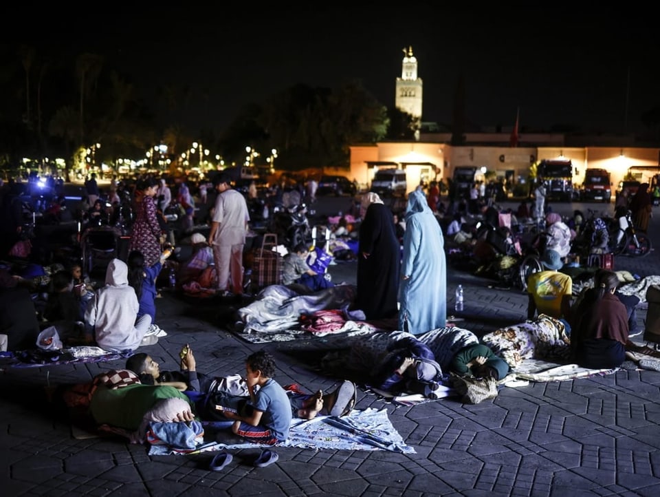 Families sit on blankets on the floor in Marrakech.
