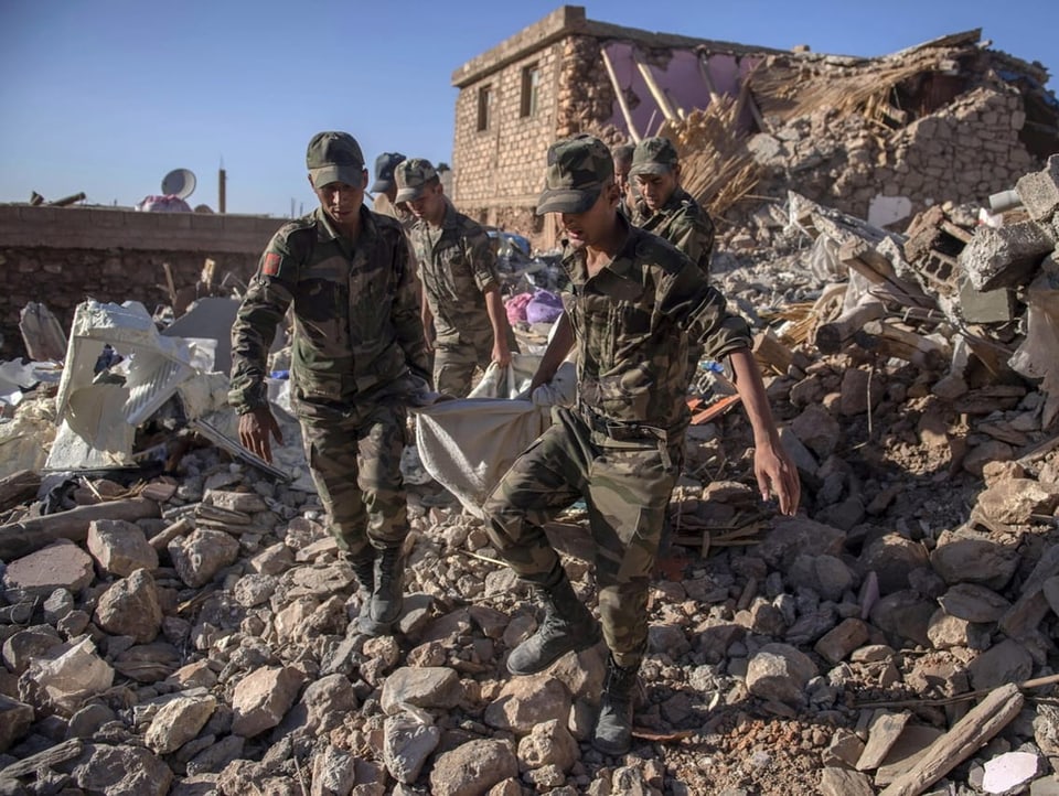 Army forces rescue a fatality from the rubble.
