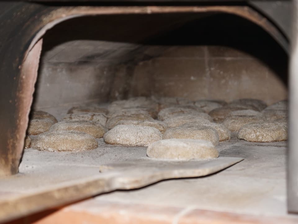 Loaves of bread are put into the oven.