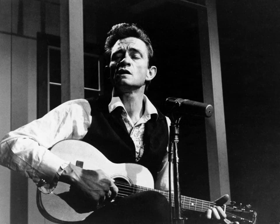 Johnny Cash sings and plays guitar.