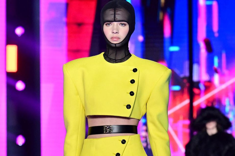The model wears a broken lemon yellow blazer dress at the Dolce&Gabbana show at Milan Fashion Week 2022.