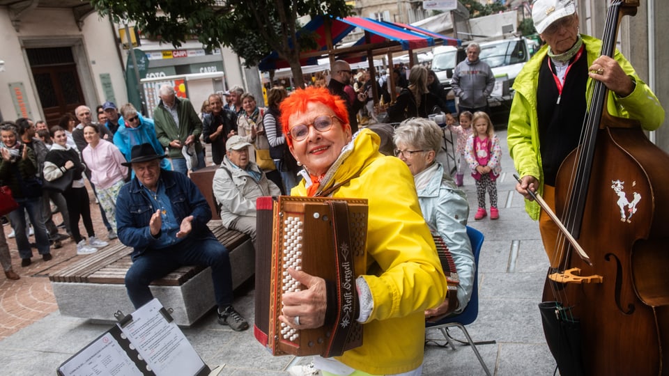 A woman with red hair plays the accordion.