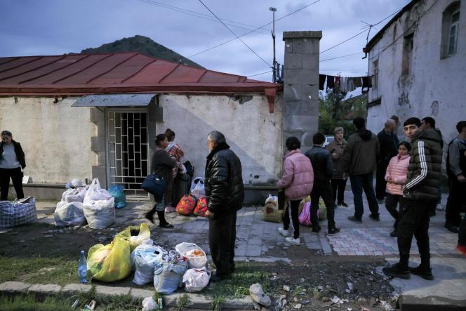 Refugees stand in Goris on September 26, 2023, before leaving for Yerevan.  An endless stream of vehicles snakes along Nagorno-Karabakh's only road towards Armenia, carrying tens of thousands of refugees now facing an uncertain future.