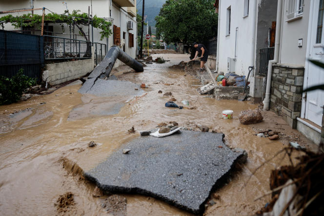People try to clean the street of mud after storm Elias hit the village of Agria, Greece, September 28, 2023. 