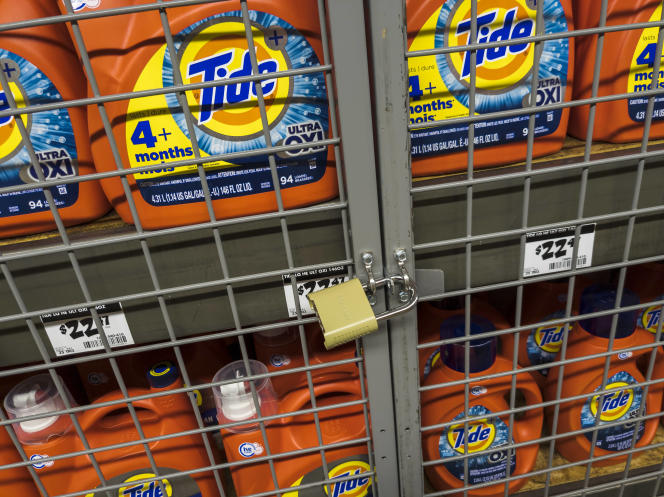 Bottles of liquid laundry detergent locked away in a store in New York, July 3, 2023.