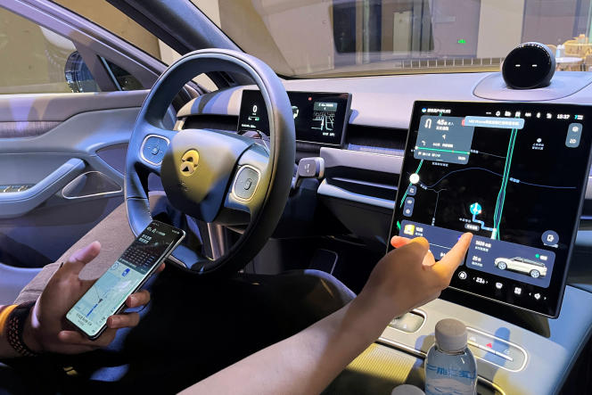 A Nio employee demonstrates to the press the connectivity of his smartphone to the screen of a car, in Shanghai, September 21, 2023.