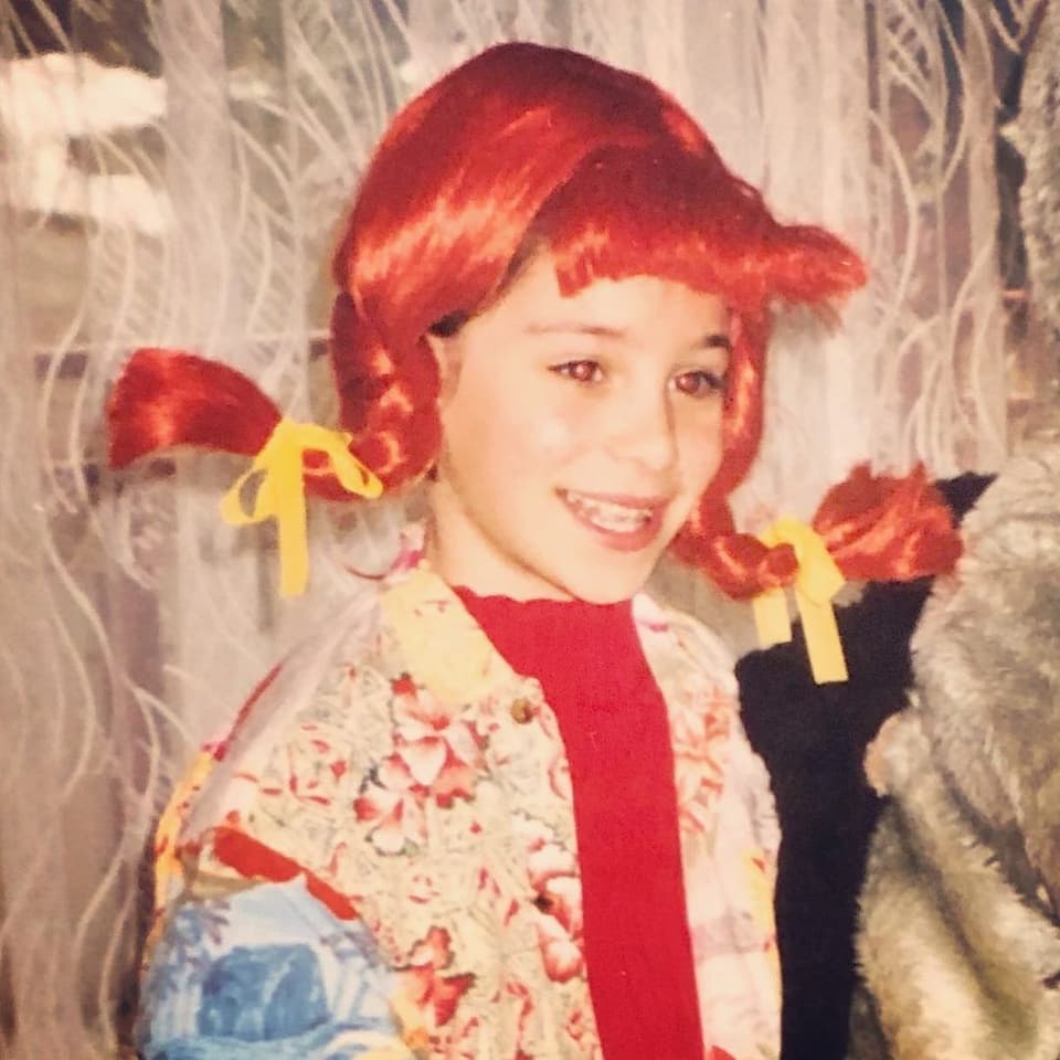 Girl dressed as Pippi Longstocking with a braided red wig