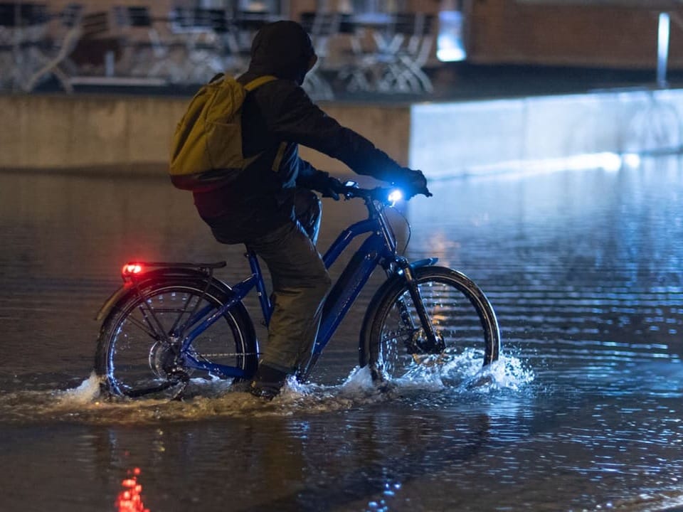 Cyclist doesn't give up despite 30 centimeters of water on the road.