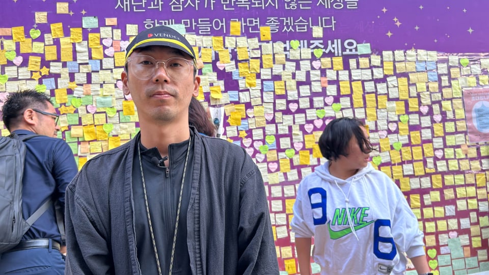 Man, behind a wall with postits