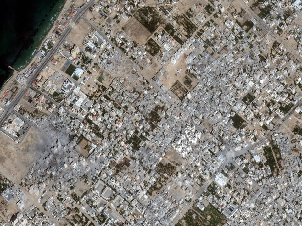 Satellite view of a city.  Destroyed neighborhoods and buildings can be seen.