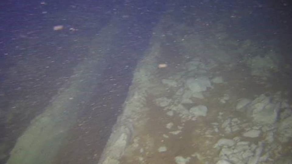 A narrow drag mark can be seen on the seabed.