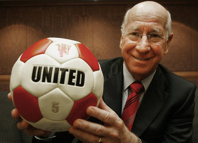 Bobby Charlton holds a ball bearing the name of his former club, Manchester United, in Hong Kong, April 19, 2005.