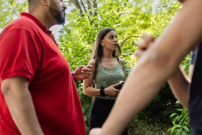 Celya Moungari (center), a street psychologist, and Nordine Lagragui (left), educator, talk with a teenager in a park in Harnes (Pas-de-Calais), June 6, 2023. 