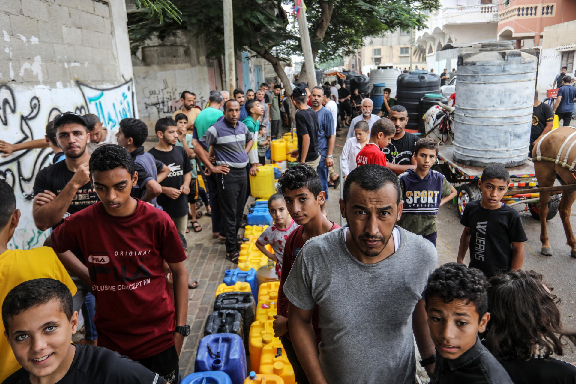 Palestinians wait at a water filling point in Rafah, Gaza Strip, October 28, 2023.