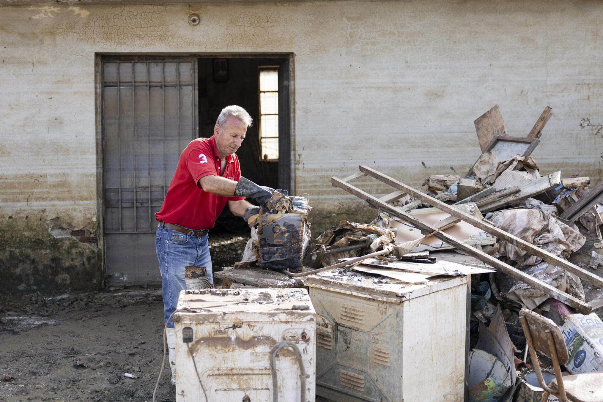 Manthos Kolonas, 63, cleans his flood-damaged house in Vlochos, Greece, on November 1, 2023.