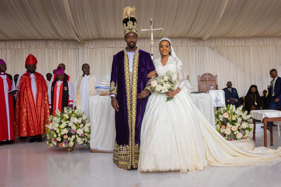 Jovia Mutesi beams in his Kate-inspired white lace dress alongside King William Gabula Nadiope IV.