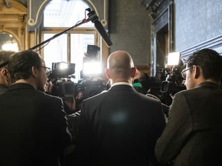 Berset is surrounded and photographed by media professionals.