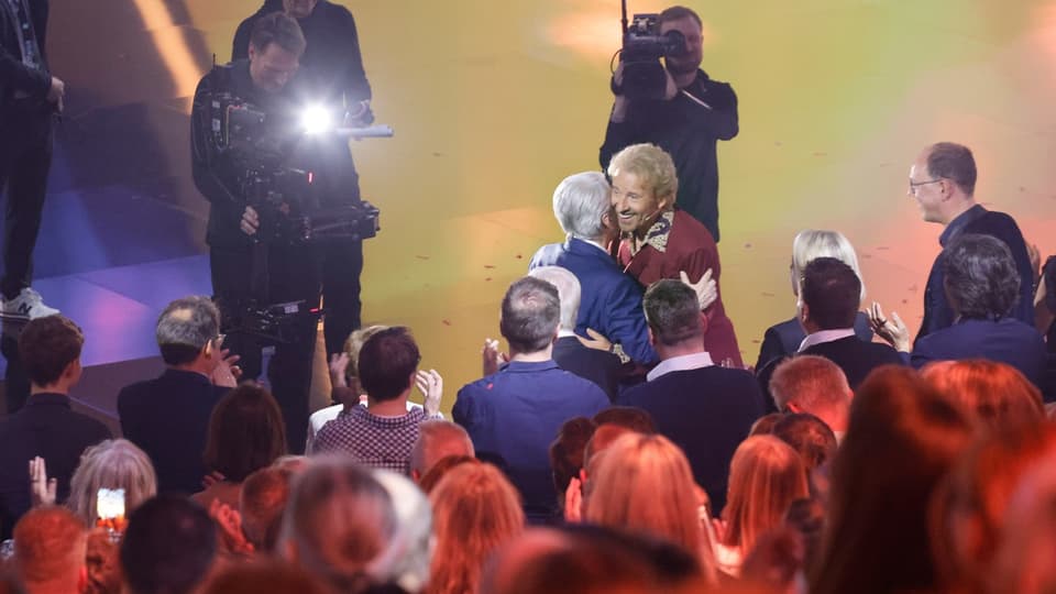 Frank Elstner hugs Thomas Gottschalk.  You stand in front of numerous people, cameramen can be seen in the background.