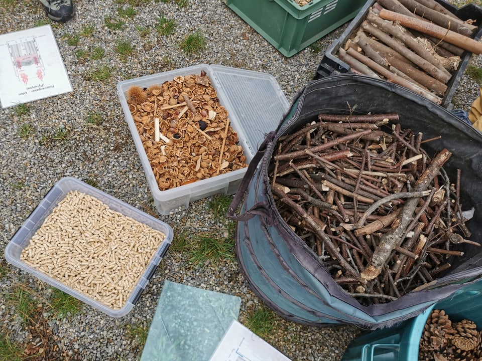 Containers filled with dried plant material sit on the ground.