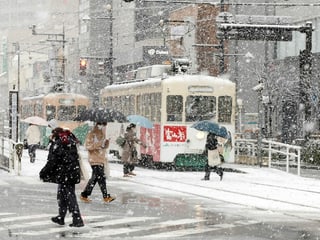 Because of its island location, Japan experiences heavy snowfall in winter.  On Honshu, the country's largest island, up to 37 meters of snow falls per year in some places.  The picture shows people with umbrellas crossing the snow-covered tram tracks in the capital Toyama during snowfall.