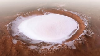There is a thick layer of ice in the Korolov Crater on Mars' northern cape.  The crater is as big as the famous Great Bear Lake in Canada.  Red rocks and dust can be seen around the crater.