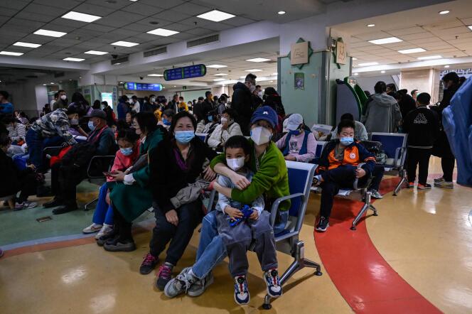 Parents wait with their children suffering from respiratory illnesses at a hospital in Beijing on November 23, 2023.