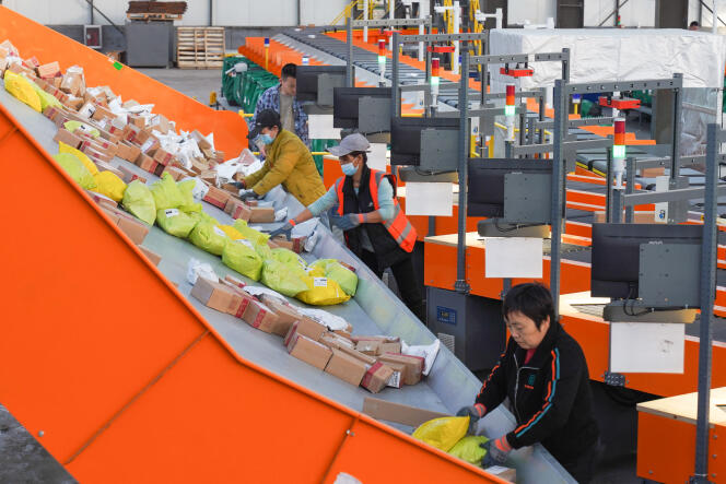 Employees at a logistics center prepare packages for 