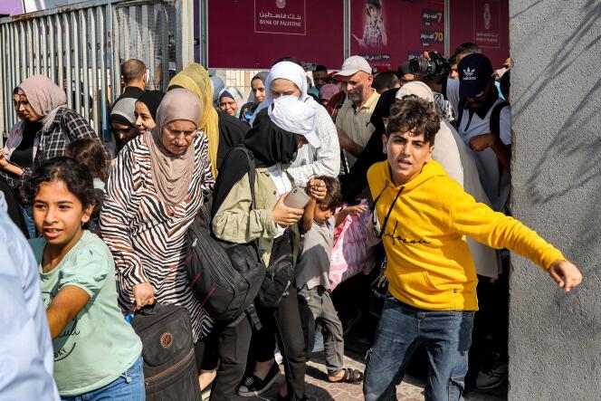Refugees pass through the Rafah border crossing in the southern Gaza Strip on November 1, 2023.