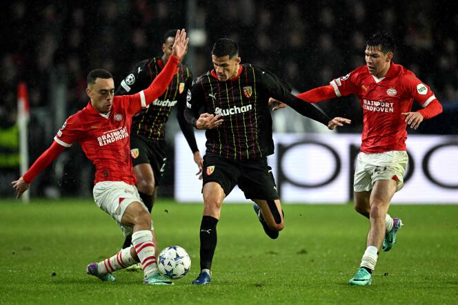 PSV defender Sergino Dest (left) and attack teammate Hirving Lozano (right) put pressure on Florian Sotoca to recover the ball during PSV - Lens (1-0), counting for the group stage of the Champions League, in Eindhoven, November 8, 2023.