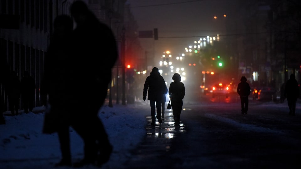 People walk through unlit, dark streets in Kiev.