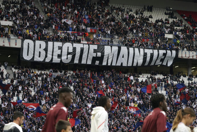 Lyon supporters hold a “Objective: maintenance” banner before the L1 match between OL and FC Metz at Groupama Stadium in Décines-Charpieu, November 5, 2023. 