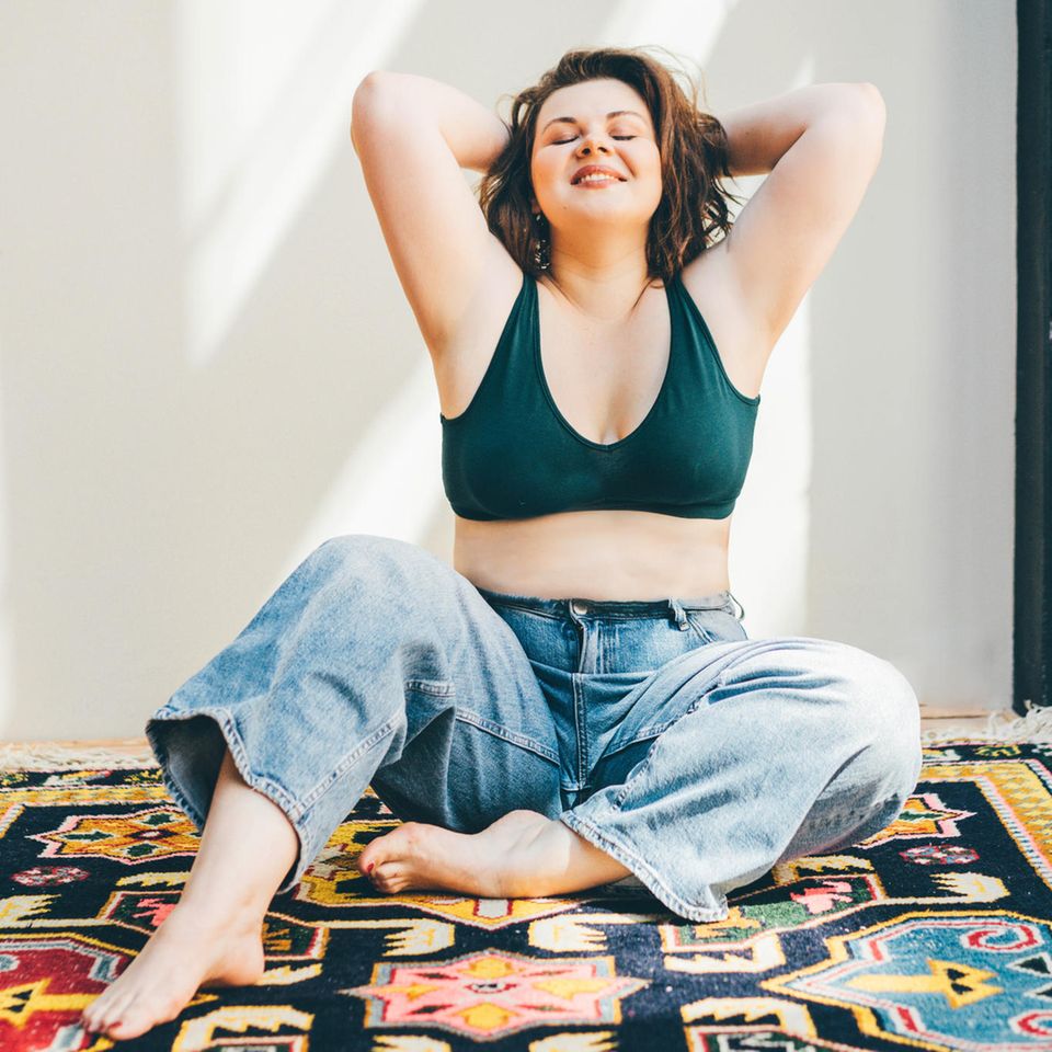 7 pillars of self-care: Happy woman sitting on the carpet