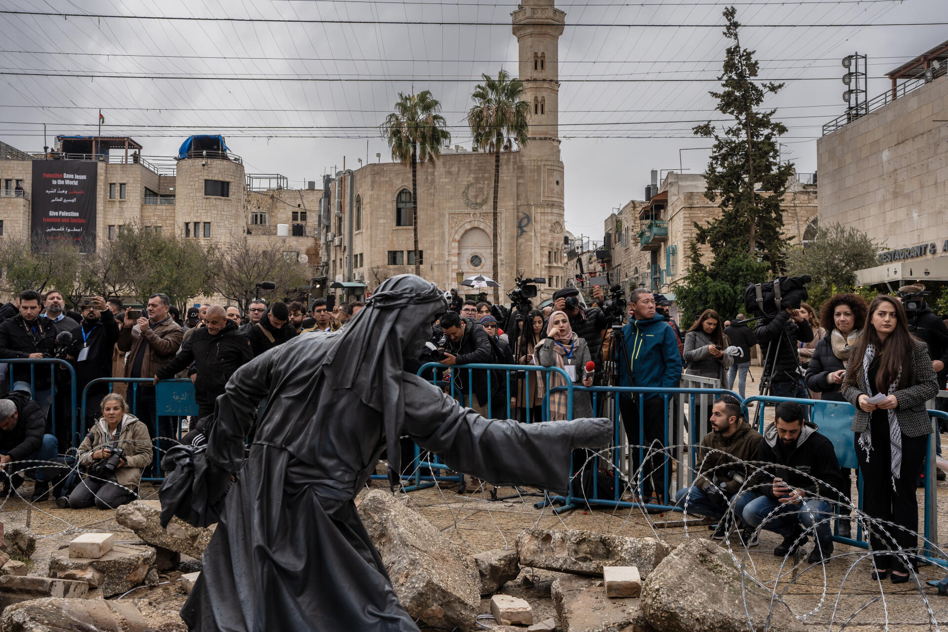 Journalists in front of “the Nativity under the rubble” which replaces the nativity scene this year to recall the ongoing horror in Gaza, in Bethlehem, West Bank, December 24, 2023. 