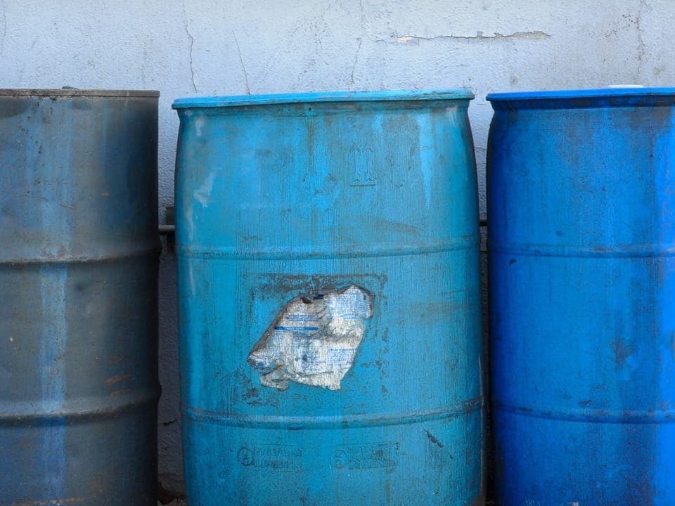 Three blue barrels standing next to each other