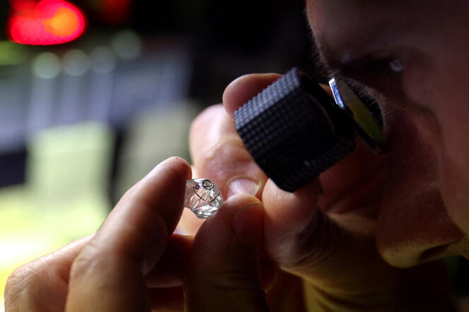 A diamond dealer observes a rough diamond in Antwerp (Belgium), October 30, 2023. 