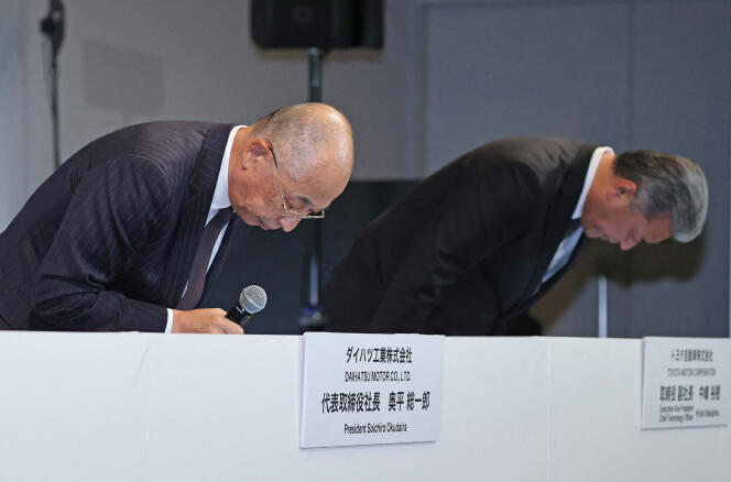 Daihatsu President Soichiro Okudaira (L) and Toyota Vice President Hiroki Nakajima apologize in Tokyo on December 20, 2023.