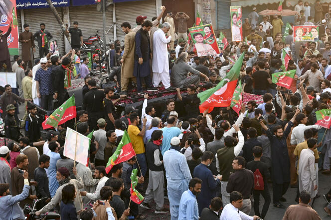 Security officers and supporters escort a vehicle carrying former Pakistani Prime Minister Imran Khan during an election campaign rally for the Punjab provincial assembly, in Lahore, March 13, 2023. 
