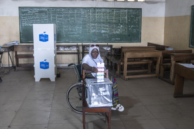 A voter places her ballot in the ballot box at a polling station, in Kinshasa, December 20, 2023.