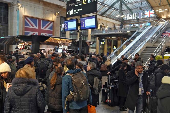 Passengers wait at the bottom of the stairs leading to the Eurostar platform at Gare du Nord in Paris, December 21, 2023, as a strike by Channel Tunnel workers blocks train traffic between France and Great Britain.