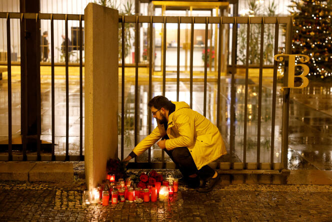 A man lays flowers in front of Charles University following a shooting, in Prague, December 21, 2023.
