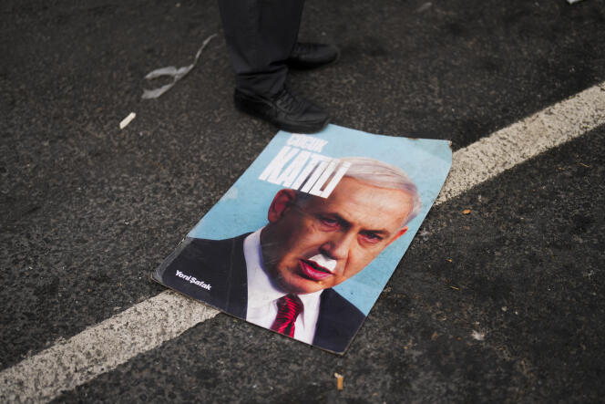 A poster caricaturing Israeli Prime Minister Benjamin Netanyahu with a mustache similar to Hitler's during a demonstration in Istanbul on January 1, 2024.